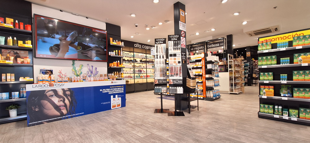 Farmac&eacute;utica con los brazos apoyados en el mostrator sonr&iacute;e